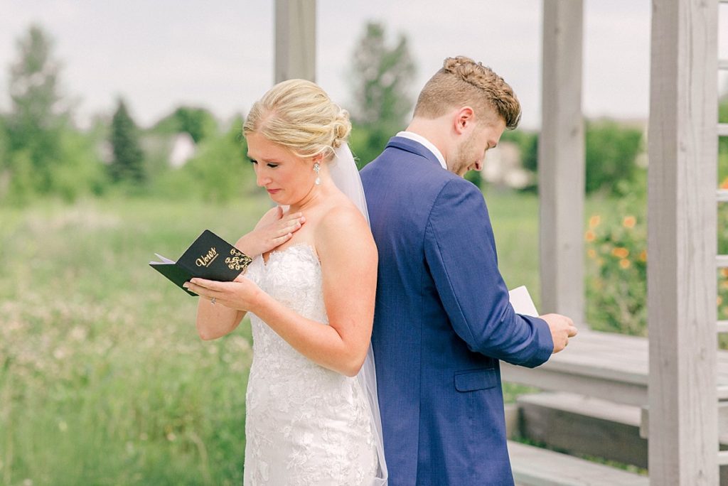 Bride reading note from groom before wedding first look