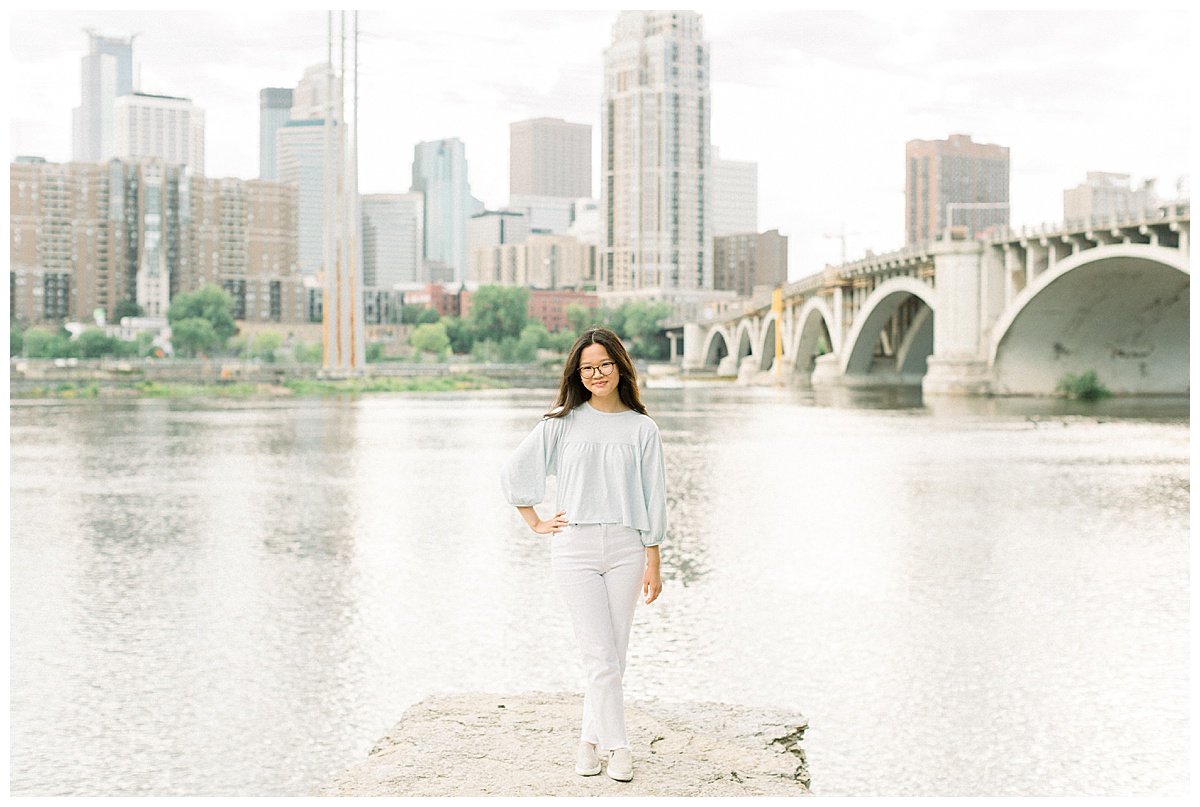 Girl smiling at the camera in front of the Minneapolis skyline.