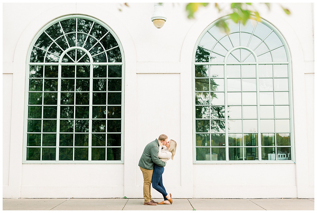 couple kissing by big windows