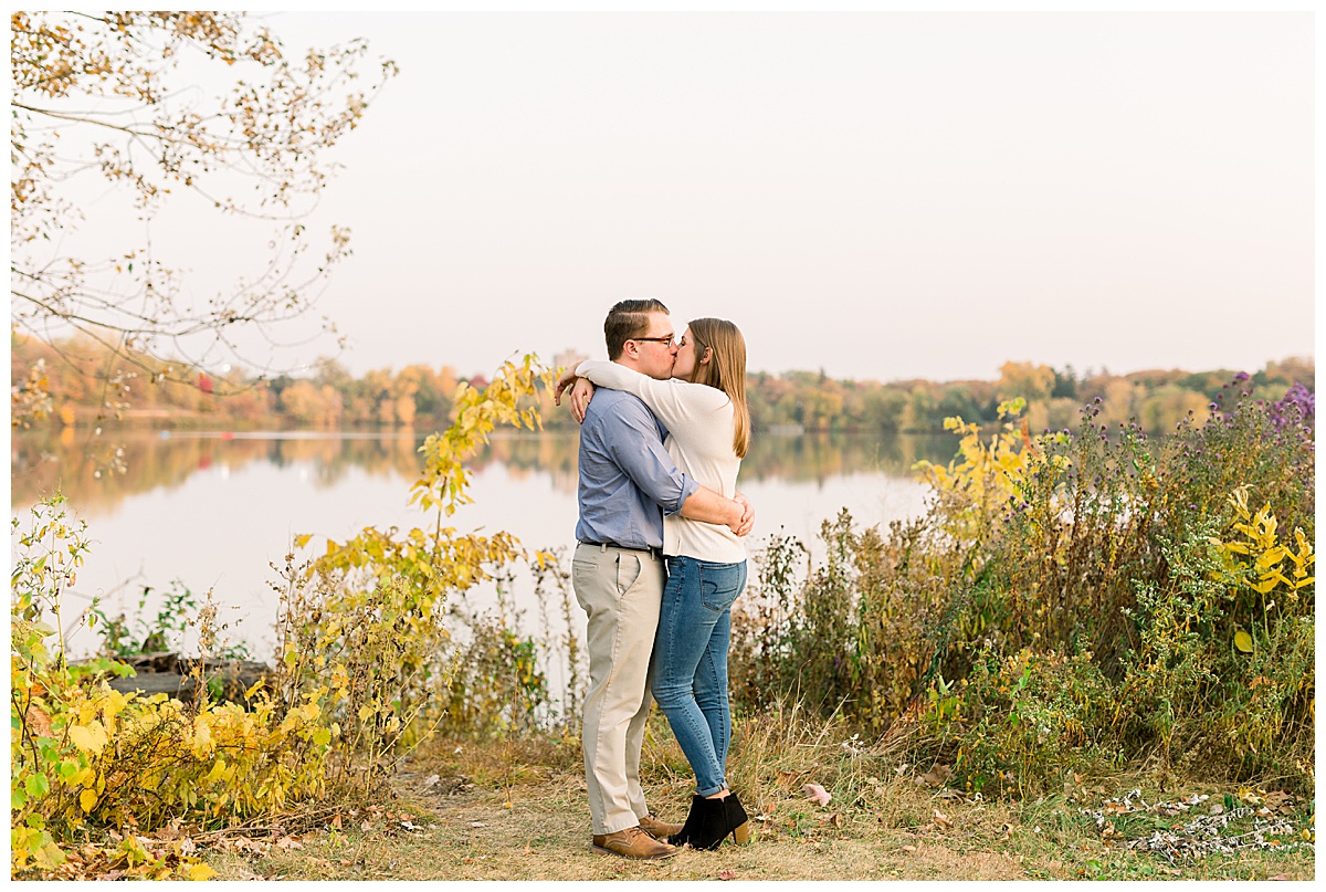 engaged couple kissing by water