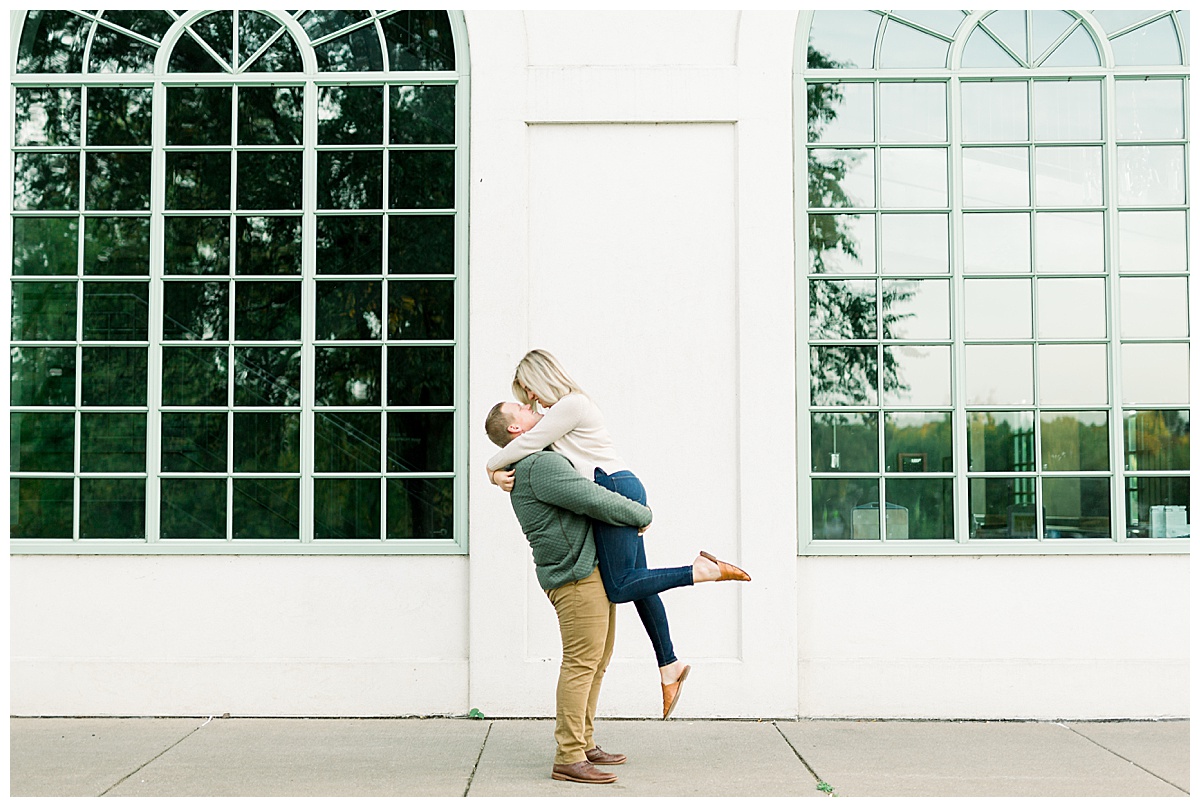 man lifts woman in engagement photos