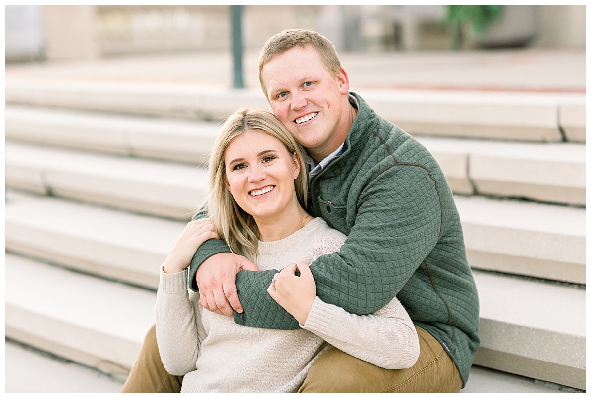 couple cuddling on steps for engagement photos
