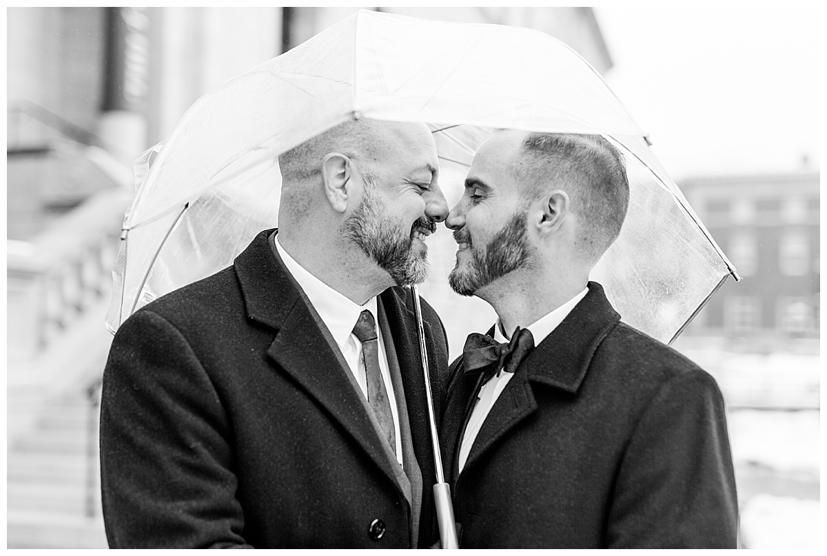 couple cuddling under umbrella in saint paul