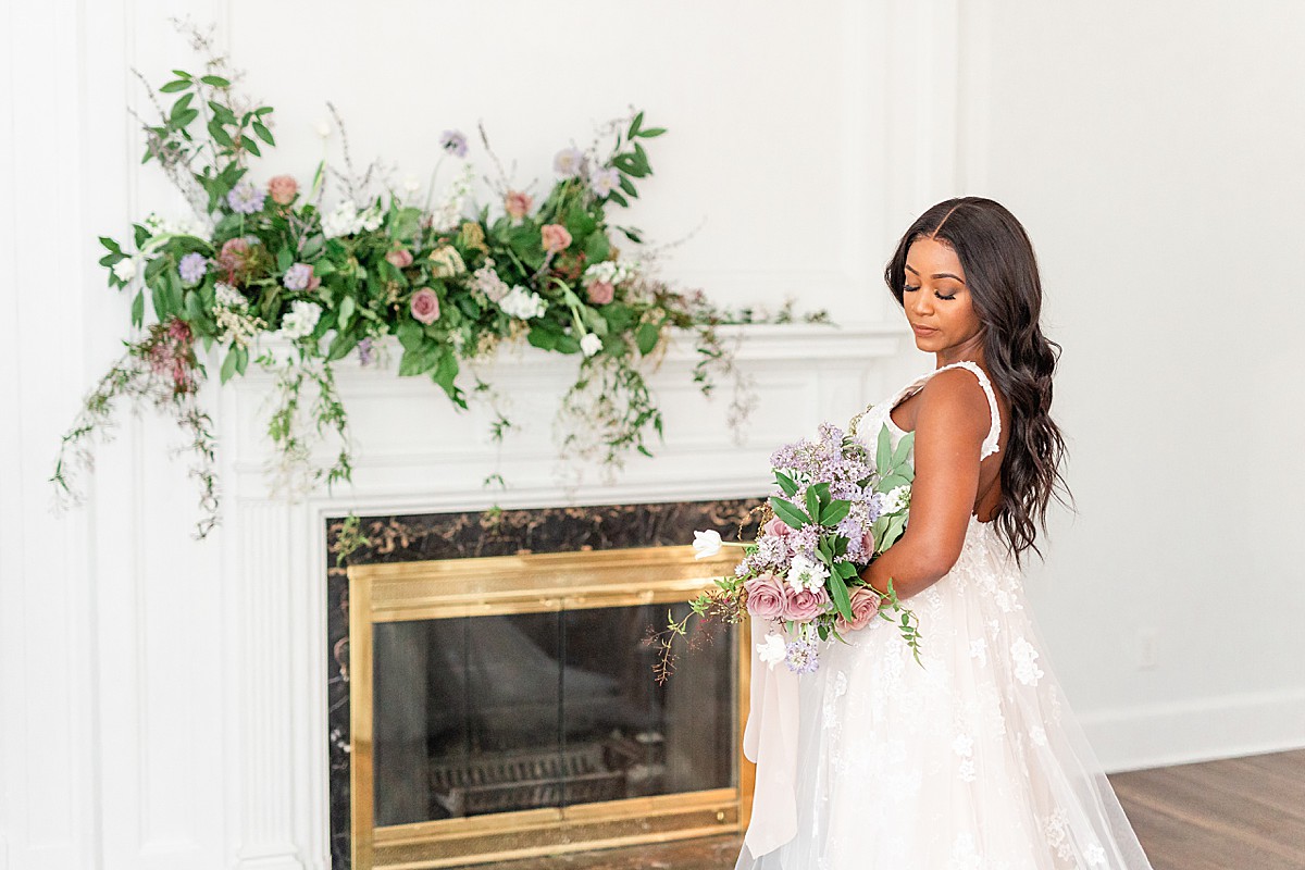 Bride with purple flowers by fireplace