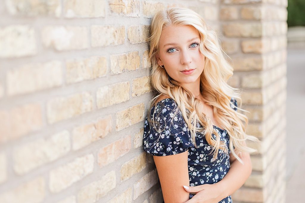 Blonde girl leaning against light bright wall
