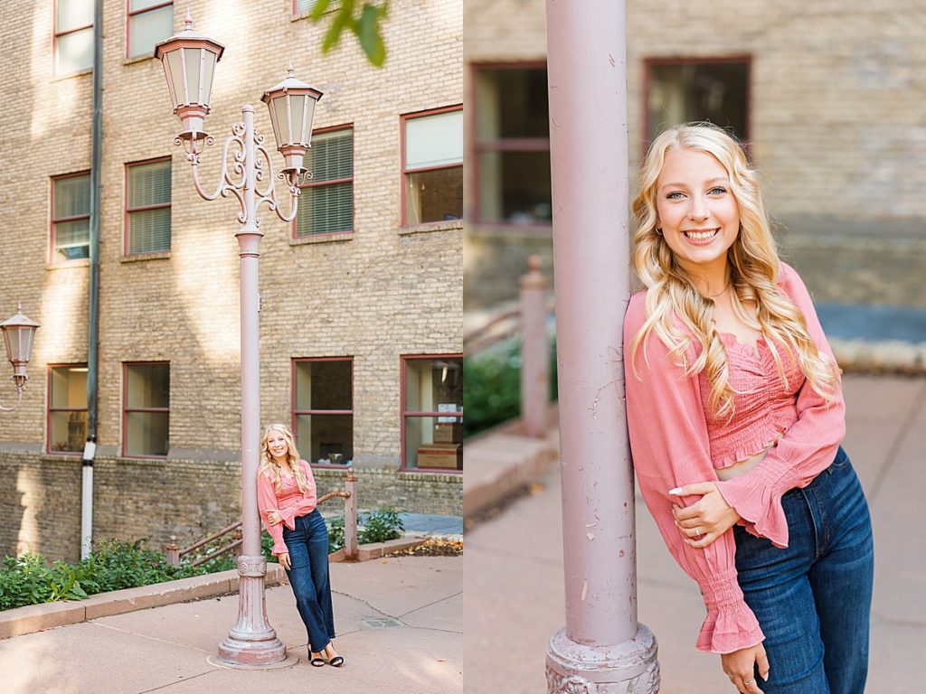 Senior girl leaning on pink lamppost in Minneapolis
